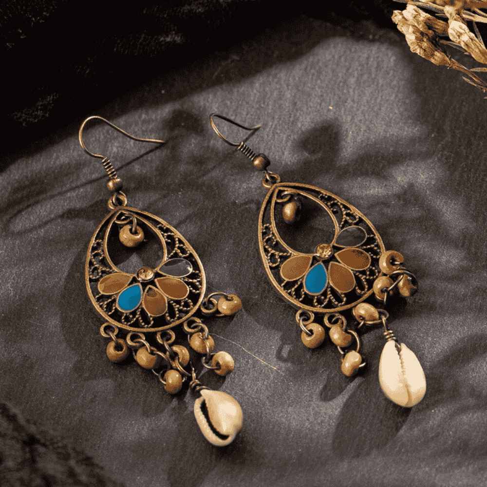 A pair of oxidised floral shell drop earrings with colorful enamel details, presented on a light background.