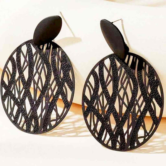 A pair of black abstract cutout boho earrings with a matte finish, featuring an oval stud and a large circular drop with intricate wavy patterns.