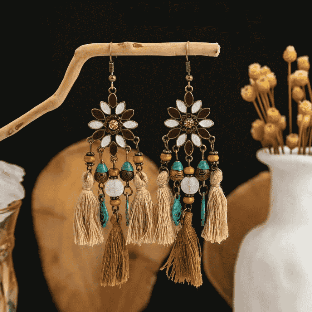 A close-up of one of the boho earrings, highlighting the detailed floral design, beaded accents, and textured tassels.