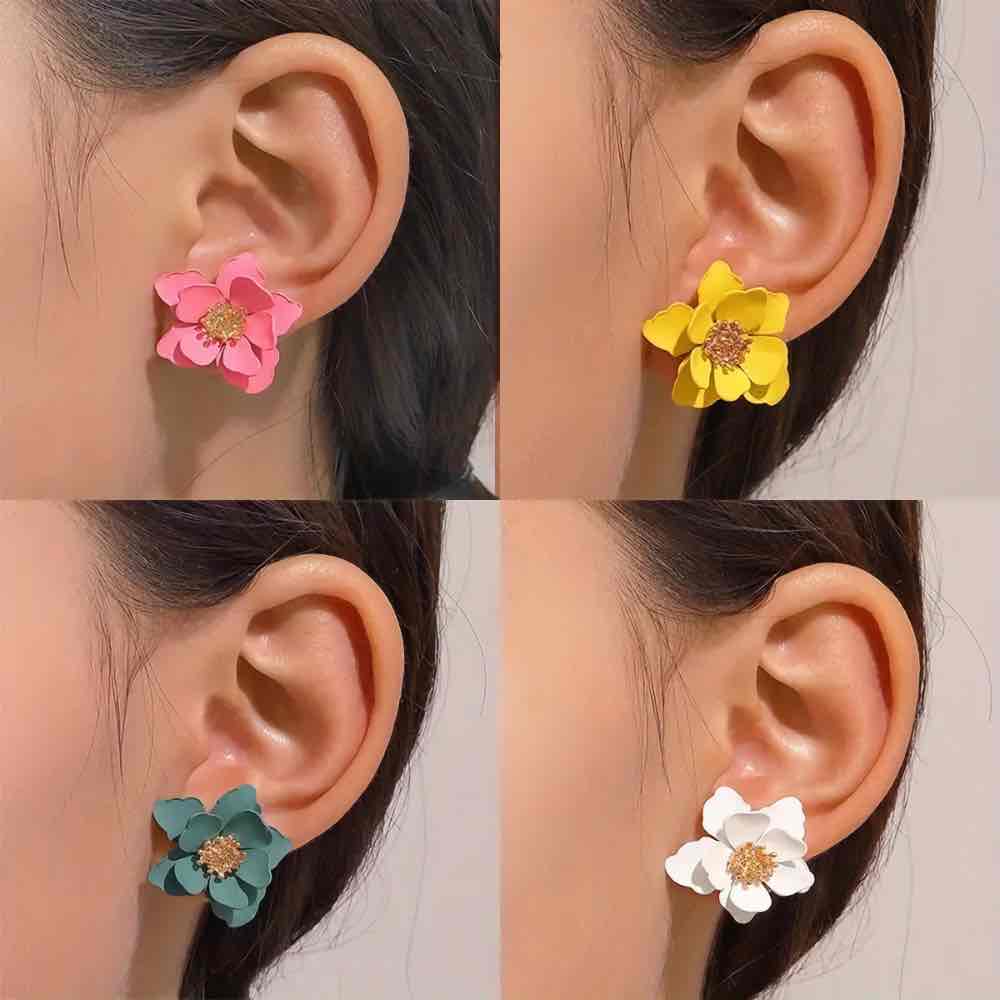 Four women wearing different colored Korean earrings in a flower stud design: pink, yellow, teal, and white.