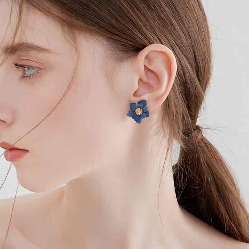A close-up of a woman wearing a yellow Korean flower stud earring.