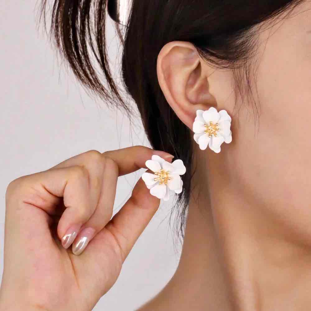 A close-up of a woman wearing a teal Korean flower stud earring.