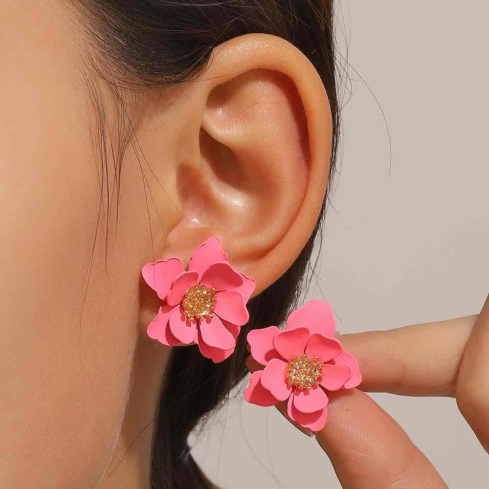 A close-up of a woman wearing a white Korean flower stud earring.