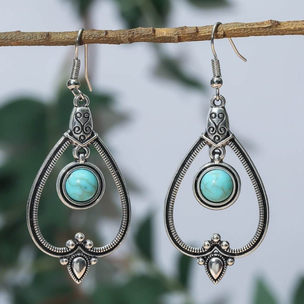 Close-up of a single oxidised boho earring with a teardrop design and turquoise stone, highlighting its intricate details.