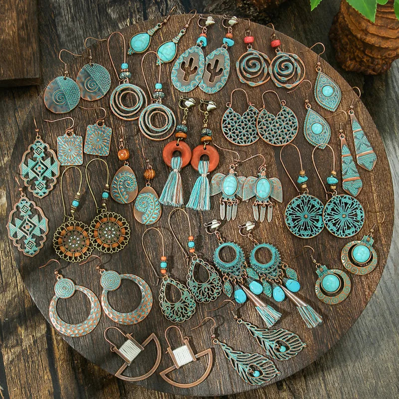 A collection of various oxidised earrings and oxidised jewellery pieces with bohemian and ethnic designs, including the featured geometric teardrop oxidised earrings, arranged on a round wooden board.