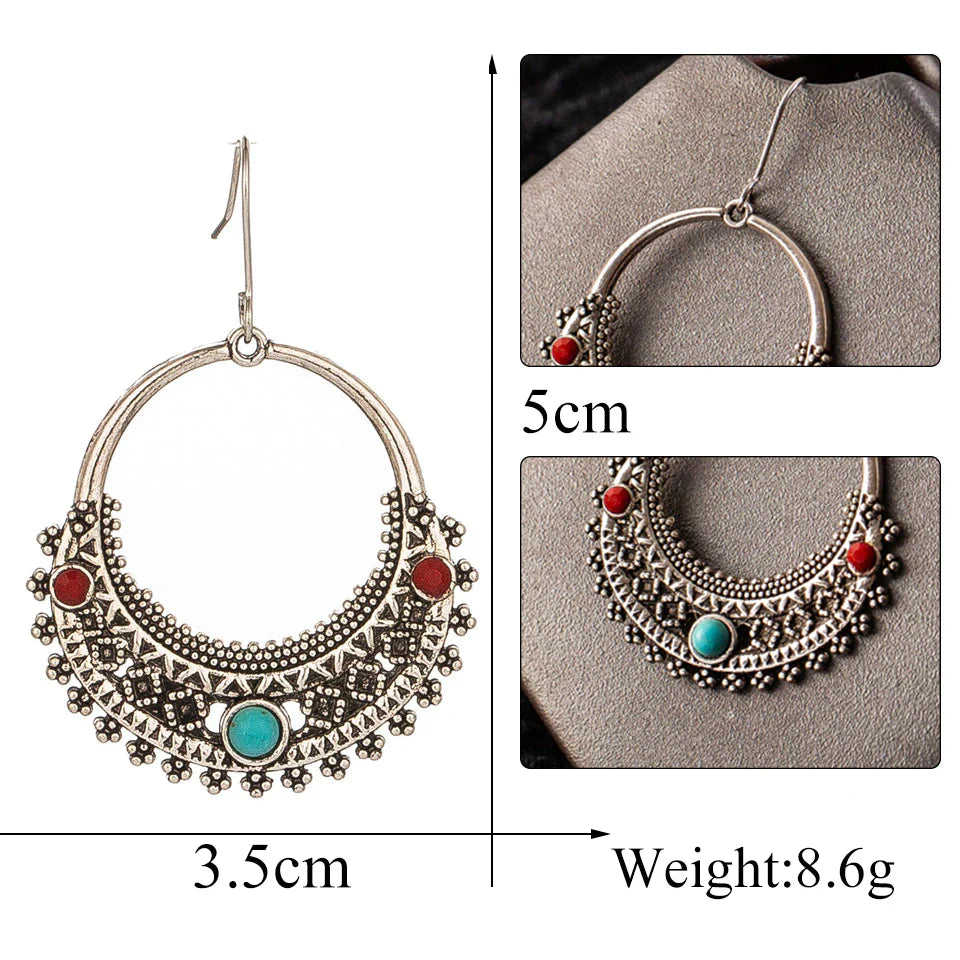 A close-up of a single oxidised tribal hoop earring with red and turquoise stones, emphasizing the detailed craftsmanship. This oxidised earring is a perfect blend of ethnic and bohemian style.