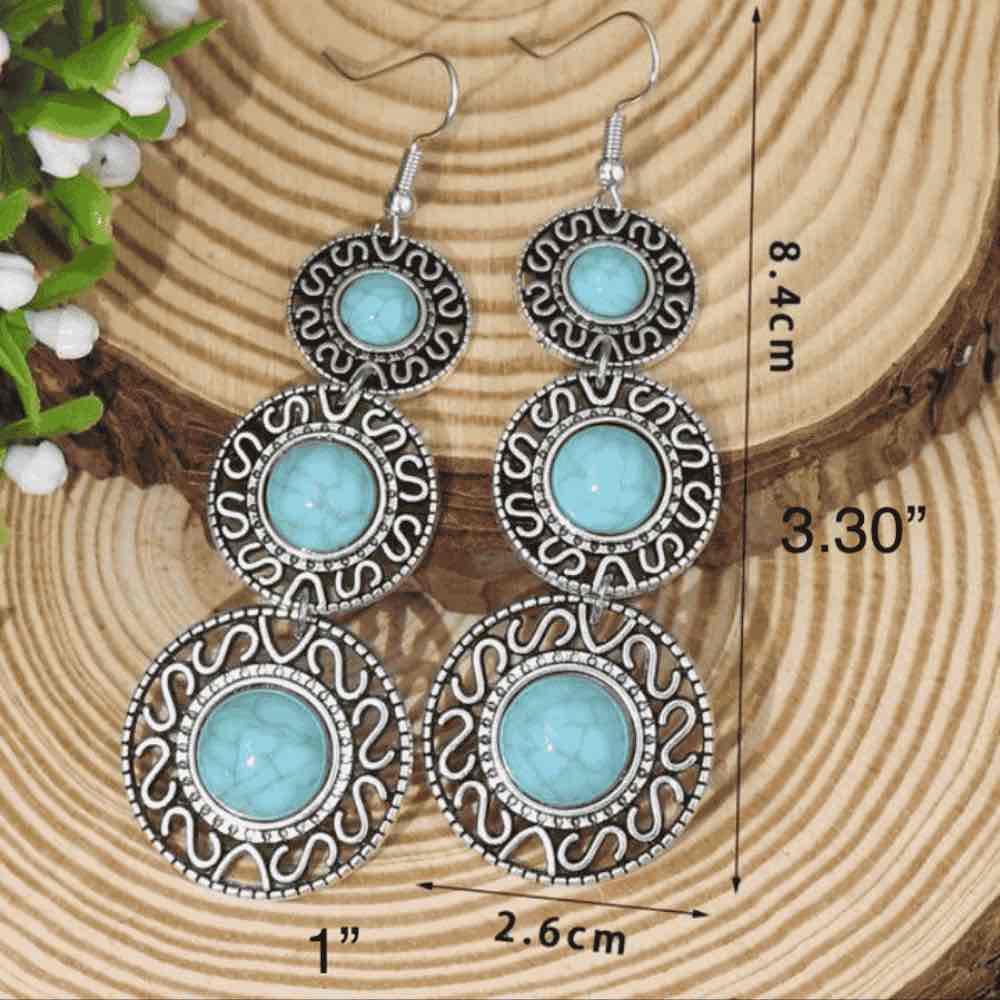 Close-up of the top two circular segments of the left turquoise earring, highlighting the stone's texture and oxidised metal 